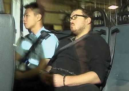 © Reuters. Rurik Jutting, who has been charged with two counts of murder, sits in a police van as it arrives at a court in Hong Kong