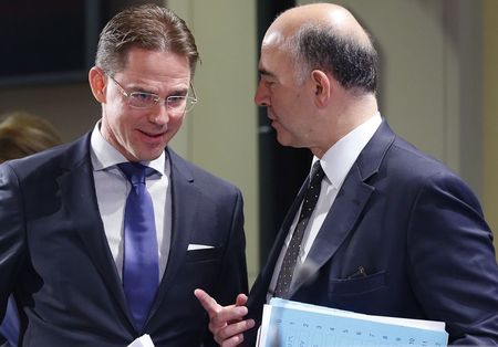 © Reuters. European commissioners Katainen and Moscovici arrive in the press room to present the EU executive's autumn economic forecasts during a news conference at the EU Commission headquarters in Brussels