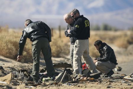 © Reuters. Investigators from the National Transportation Safety Board (NTSB) look at wreckage from the crash of Virgin Galactic's SpaceShipTwo near Cantil, California