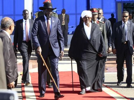 © Reuters. Sudanese President Omar al-Bashir walks with his  South Sudan counterpart Salva Kiir after their meeting at Khartoum's airport