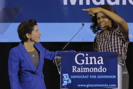 © Reuters. United States first lady Obama gestures to Democratic candidate for Rhode Island Governor Raimondo at a campaign rally in Providence