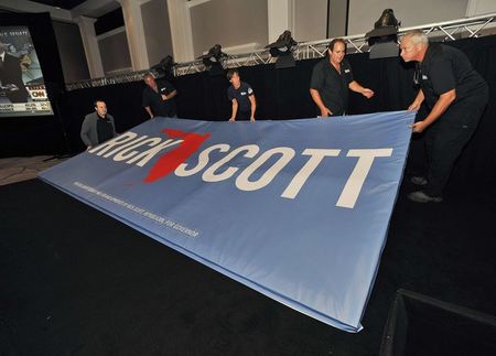 © Reuters. Workers prepare a banner on stage for Republican Florida Governor Scott during a U.S. midterm elections night party in Bonita Springs, Florida