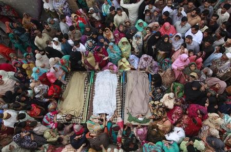 © Reuters. Relatives gather beside the bodies of victims who were killed in yesterday's suicide bomb attack on the Wagah border, before funeral prayers in Lahore