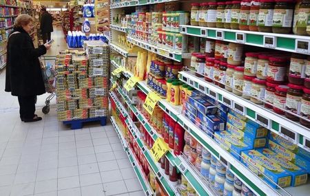 © Reuters. A woman checks for prices in a supermarket in Rome