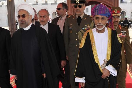 © Reuters. Oman's Sultan Qaboos bin Said walks with Iran's President Hassan Rouhani upon Rouhani's arrival in Muscat