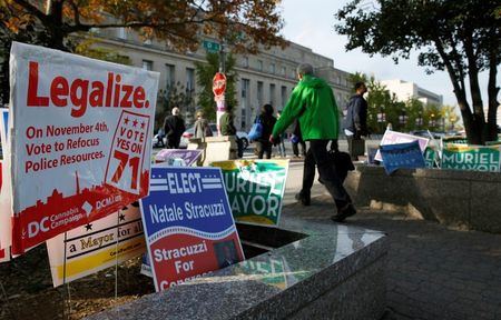 © Reuters. Pedestrians pass by a DC Cannabis Campaign sign in Washington