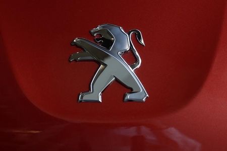 © Reuters. A Peugeot logo is seen on a car displayed at PSA Peugeot Citroen headquarters in Paris after the company's 2014 First-Half results presentation