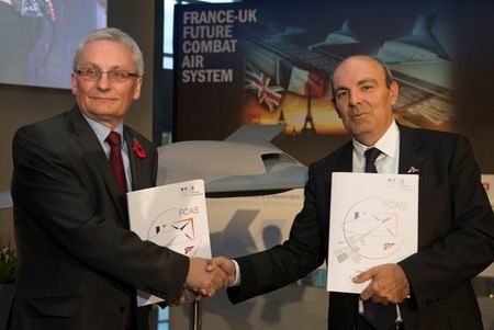 © Reuters. Chairman and CEO of Dassault Aviation Eric Trappier and CEO of BAE Systems Ian King pose with a model of the Future Combat Air System during a ceremony at Dassault headquarters in Saint Cloud