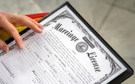 © Reuters. Reverend Hotze-Wilton signs a marriage license at a same-sex wedding ceremony at City Hall in St. Louis