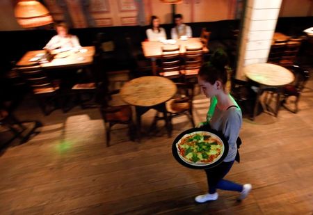 © Reuters. A waitress serves pizza at a restaurant in Moscow