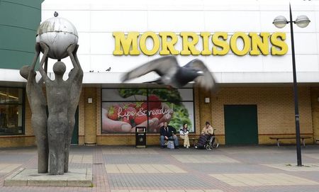 © Reuters. People sit outside a Morrisons store in Stratford east London