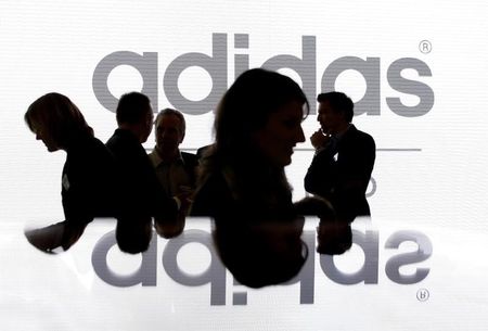 © Reuters. Акционеры Adidas Group на фоне логотипа компании перед началом общего собрания акционеров 