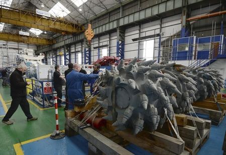 © Reuters. Employees stand near components of a subsea mining machine being assembled by Soil Machine Dynamics for Nautilus Minerals at Wallsend