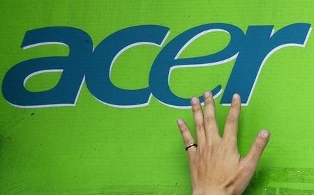 © Reuters. A man's hand is seen on an Acer logo as he pastes a poster below at a computer mart in Taipei