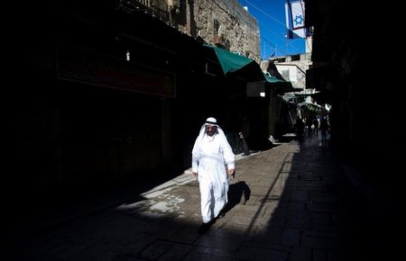 © Reuters. A Muslim man walks past an Israeli flag in the Old City of Jerusalem