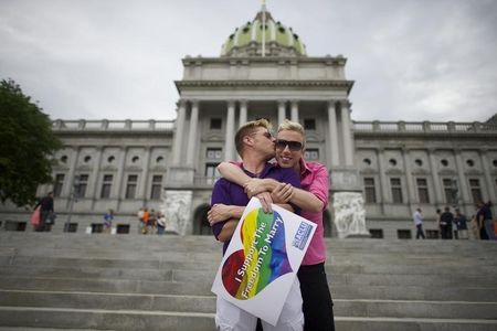 © Reuters. A couple embraces on the Pennsylvania State Capital steps following a rally with gay rights supporters in Harrisburg