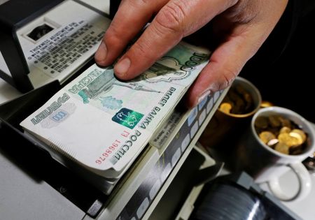 © Reuters. An employee uses a machine to count Russian roubles at a private company's office in Krasnoyarsk