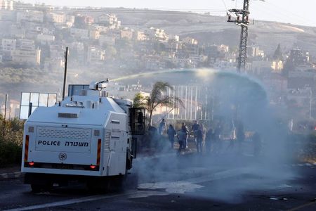 © Reuters. An Israeli police truck sprays water during during clashes between Arab youths and Israeli police at the entrance to the town of Kfar Kanna, in northern Israel