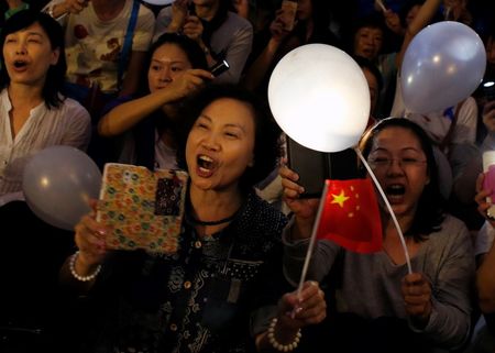 © Reuters. Anti-Occupy Central protesters sing while holding luminous ballons and Chinese flags during a rally in Hong Kong