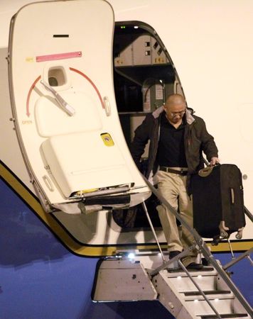 © Reuters. Kenneth Bae carries luggage as he disembarks from a U.S. Air Force jet at McChord Field at Joint Base Lewis-McChord, Washington