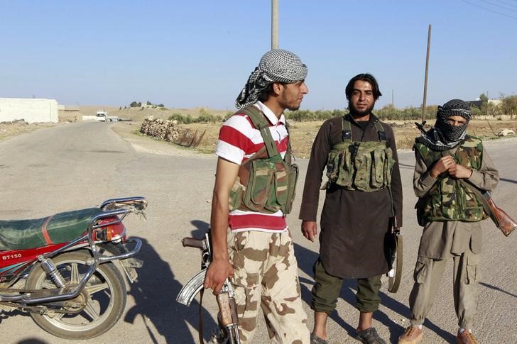 © Reuters. Islamic State fighters stand along a street in the countryside of the Syrian Kurdish town of Kobani, after taking control of the area