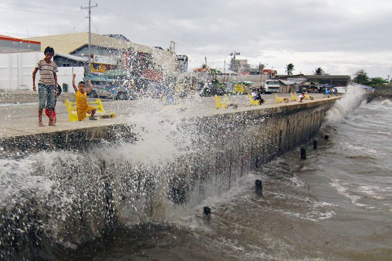 © Reuters. Waves, brought by Typhoon Hagupit, hit the concrete barrier along the Boulevard Seaport in Surigao City
