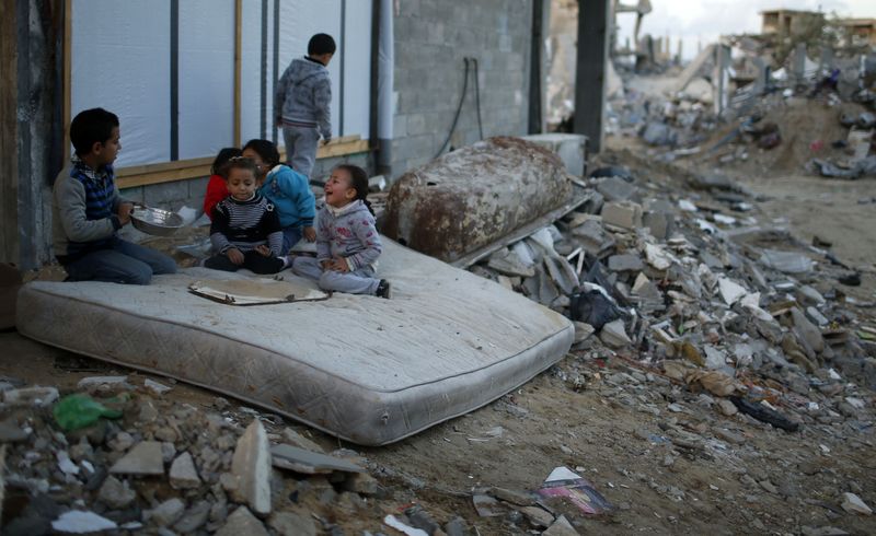 © Reuters. Palestinian children play on a mattress near ruins of houses which witnesses said were destroyed by Israeli shelling during most recent conflict in Gaza City