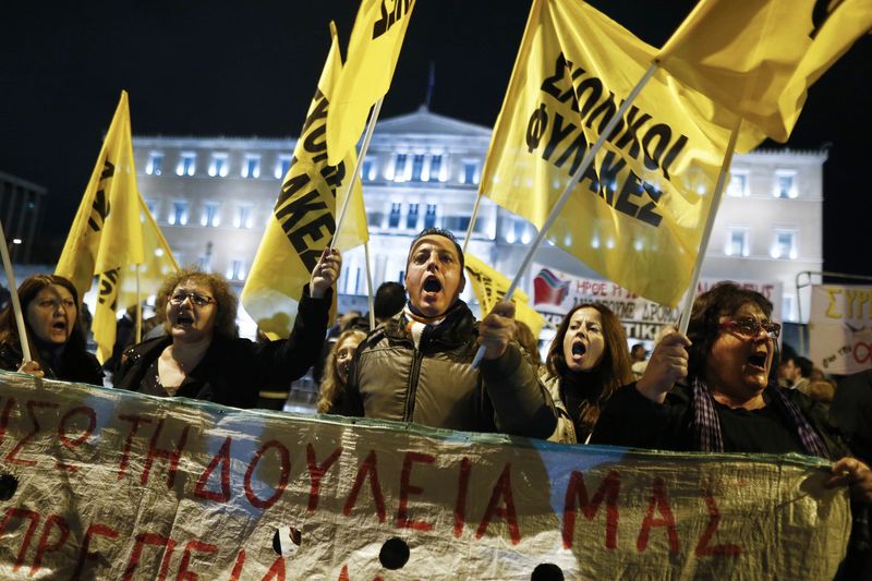 © Reuters. Protesters shout slogans during a rally outside the Greek parliament where lawmakers vote on the 2015 budget in Athens