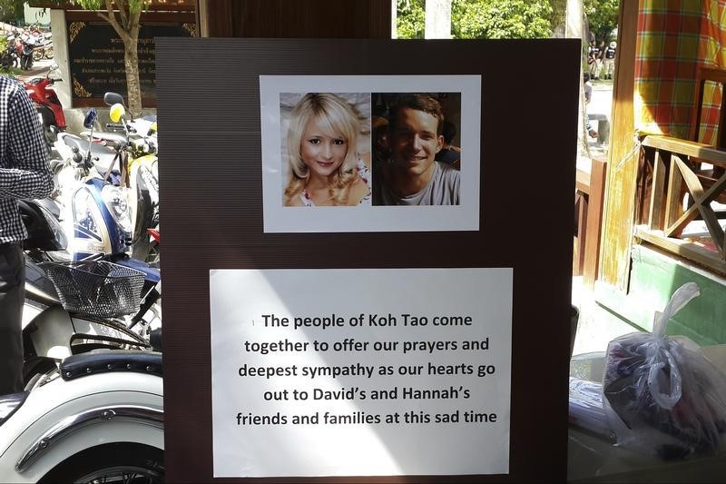 © Reuters. Pictures of killed British tourists David Miller and Hannah Witheridge and a message of support to their friends and families are displayed during special prayers at Koh Tao island
