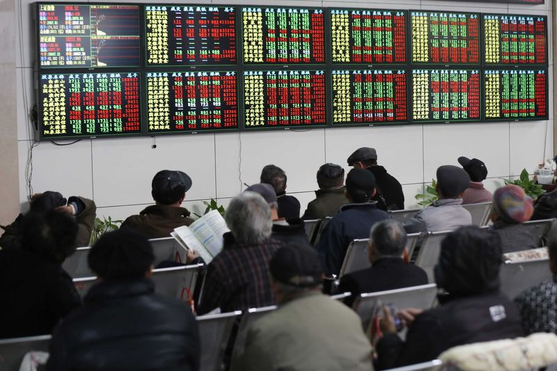 © Reuters. Investors look at information displayed on an electronic screen at a brokerage house in Shanghai