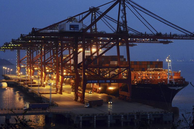 © Reuters. Trucks loaded with cargo containers are seen at Ningbo Zhoushan Port