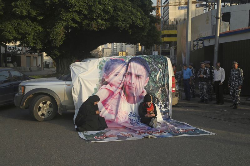 © Reuters. Relatives of Lebanese soldiers, who were captured by Islamist militants in Arsal, sit near a vehicle with a banner of soldier Ali al-Bazzal, during a protest as families block entrance of downtown Beirut