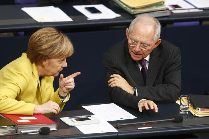 © Reuters. German Chancellor Merkel talks with Finance Minister Schaeuble prior to vote on the federal budget at Bundestag in Berlin