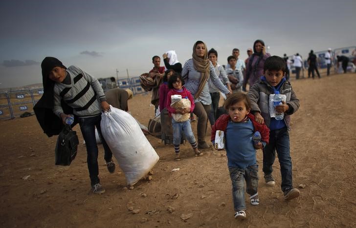 © Reuters. File photo of Kurdish Syrian refugees carrying their belongings after crossing the Turkish-Syrian border near the southeastern town of Suruc in Sanliurfa province
