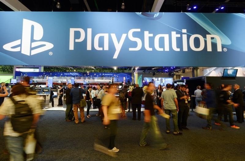 © Reuters. Attendees walk past the Sony Playstation booth at the 2014 Electronic Entertainment Expo, known as E3, in Los Angeles