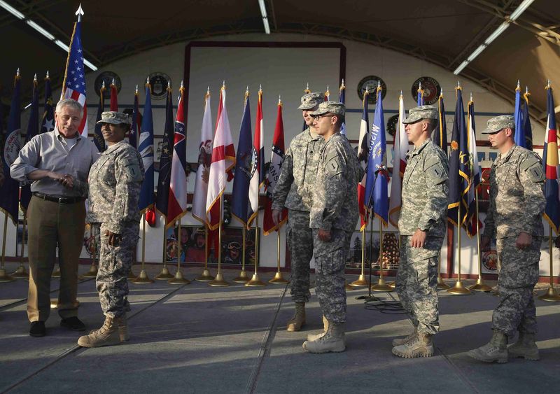 © Reuters. U.S. Defense Secretary Hagel shakes hands with U.S. Army Spc. Whitely of Jamaica during a visit with U.S. troops at Camp Buehring, Kuwait