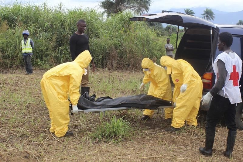 © Reuters. Agentes carregam corpo de vítima do Ebola em Serra Leoa