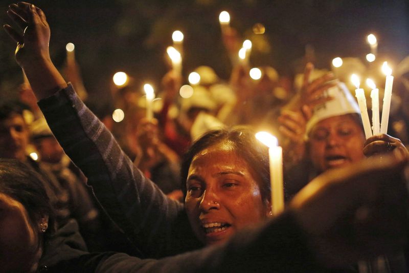 © Reuters. Supporters of AAP shout slogans as they participate in a candle light vigil during a protest against the rape of a female passenger, in New Delhi