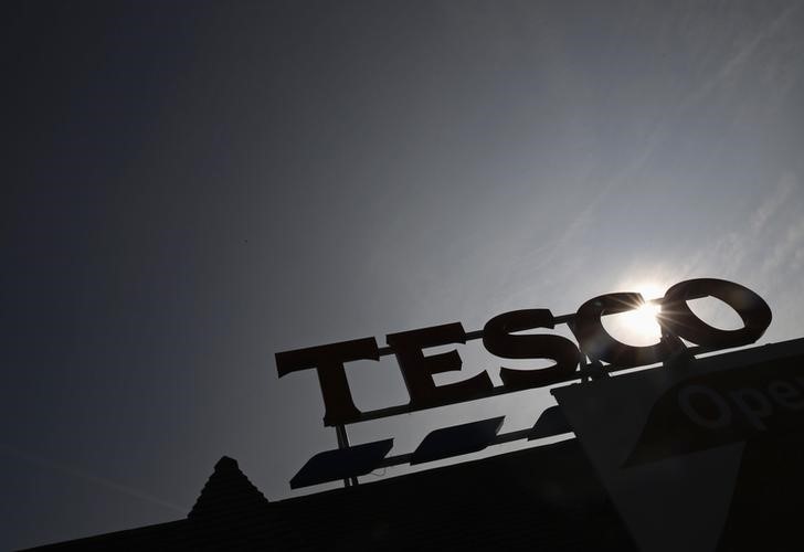 © Reuters. The signage of Tesco Extra is silhouetted against the sun in southwest London