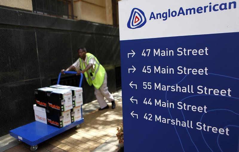 © Reuters. A worker pushes a trolley past a board outside the Anglo American offices in Johannesburg