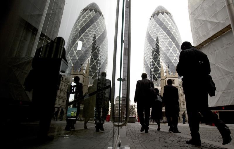 © Reuters. Workers walk through the City of London