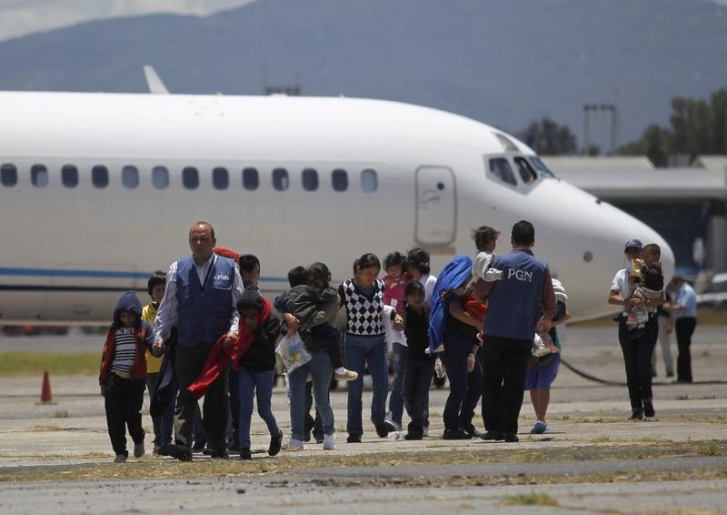 © Reuters. Guatemalan families, deported from Phoenix, Arizona in the U.S., walk at an air force base after arriving on a flight transporting illegal Guatemalan migrants, in Guatemala City