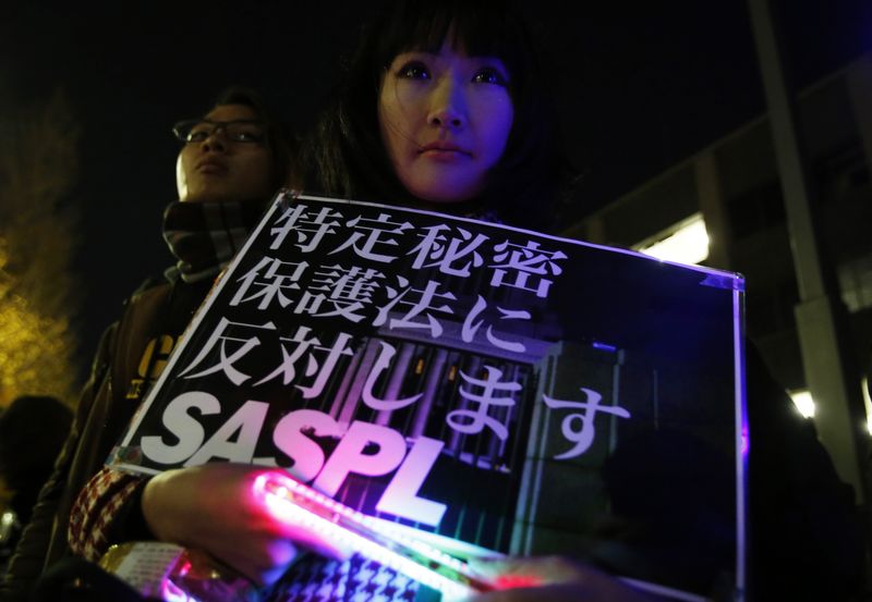 © Reuters. A protester holding a placard demonstrates against a state-secrets law during a rally in Tokyo