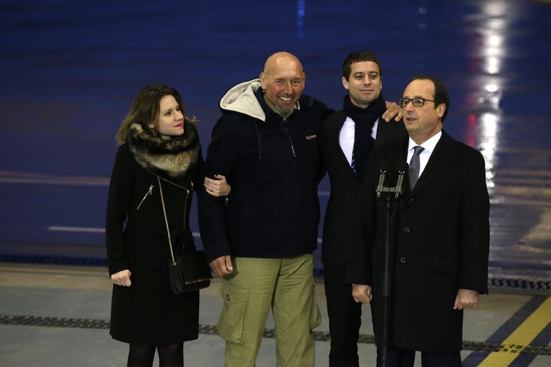 © Reuters. Former hostage Lazarevic, his daughter Diane, French President Hollande and Clement, the son of Philippe Verdon, address media after his arrival at the Villacoublay military airport