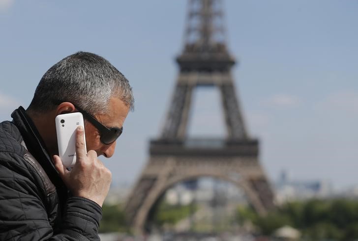 © Reuters. A man makes a phone call using his mobile phone at the Trocadero Square near the Eiffel Tower in Paris