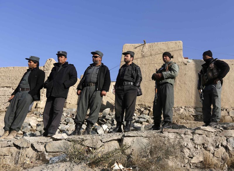 © Reuters. Afghan policemen look at the site of a suicide attack in Kabul