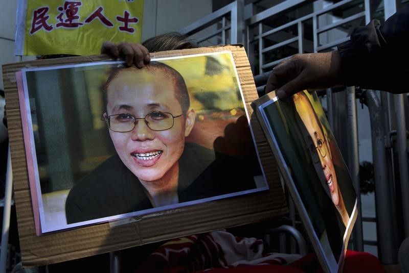 © Reuters. Pro-democracy protester holds portrait of Liu Xia, wife of jailed Nobel Peace Prize Laureate Liu Xiaobo, during protest to call for freeing of Chinese dissidents  outside Chinese liaison office in Hong Kong
