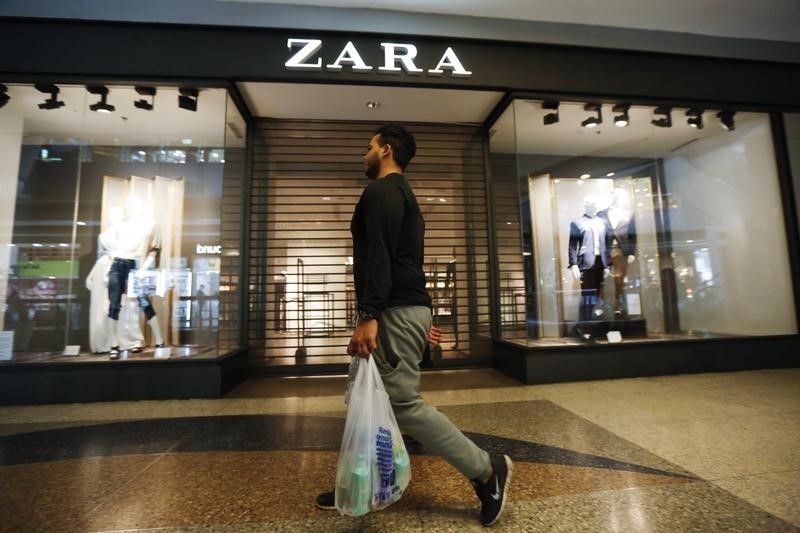 © Reuters. A man walks past a Zara retail store, with its shutters drawn, at a mall in Caracas
