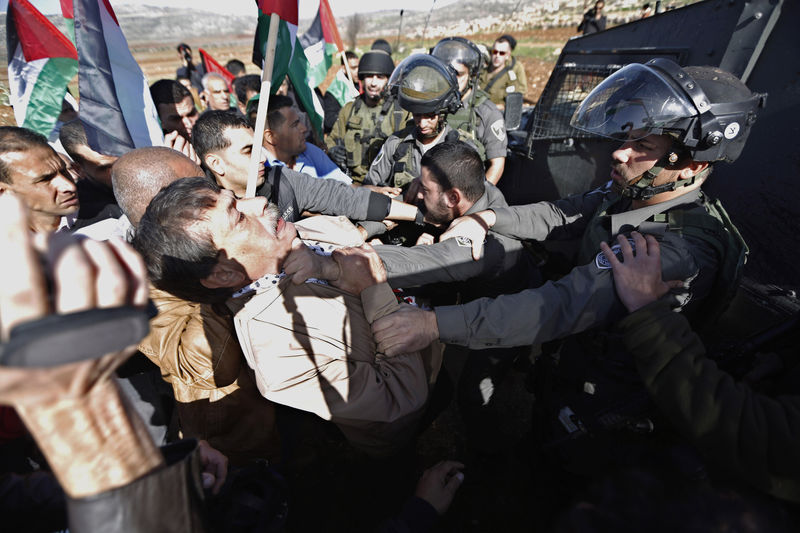 © Reuters. Ministro palestino Ziad Abu Ein é agarrado pelo pescoço por policial israelense em Ramallah