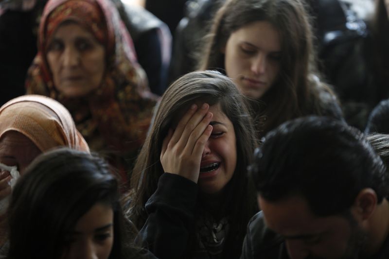 © Reuters. Relative of  Palestinian minister Ziad Abu Ein mourns during his funeral in the West Bank city of Ramallah